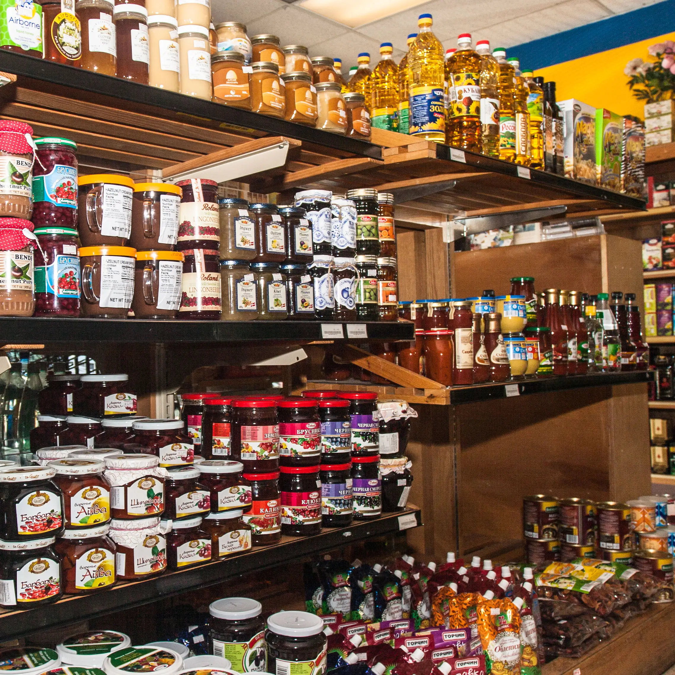 Shelves at Aleksey's Market stocked with jams, preserves, oils, sauces, and imported pantry goods.