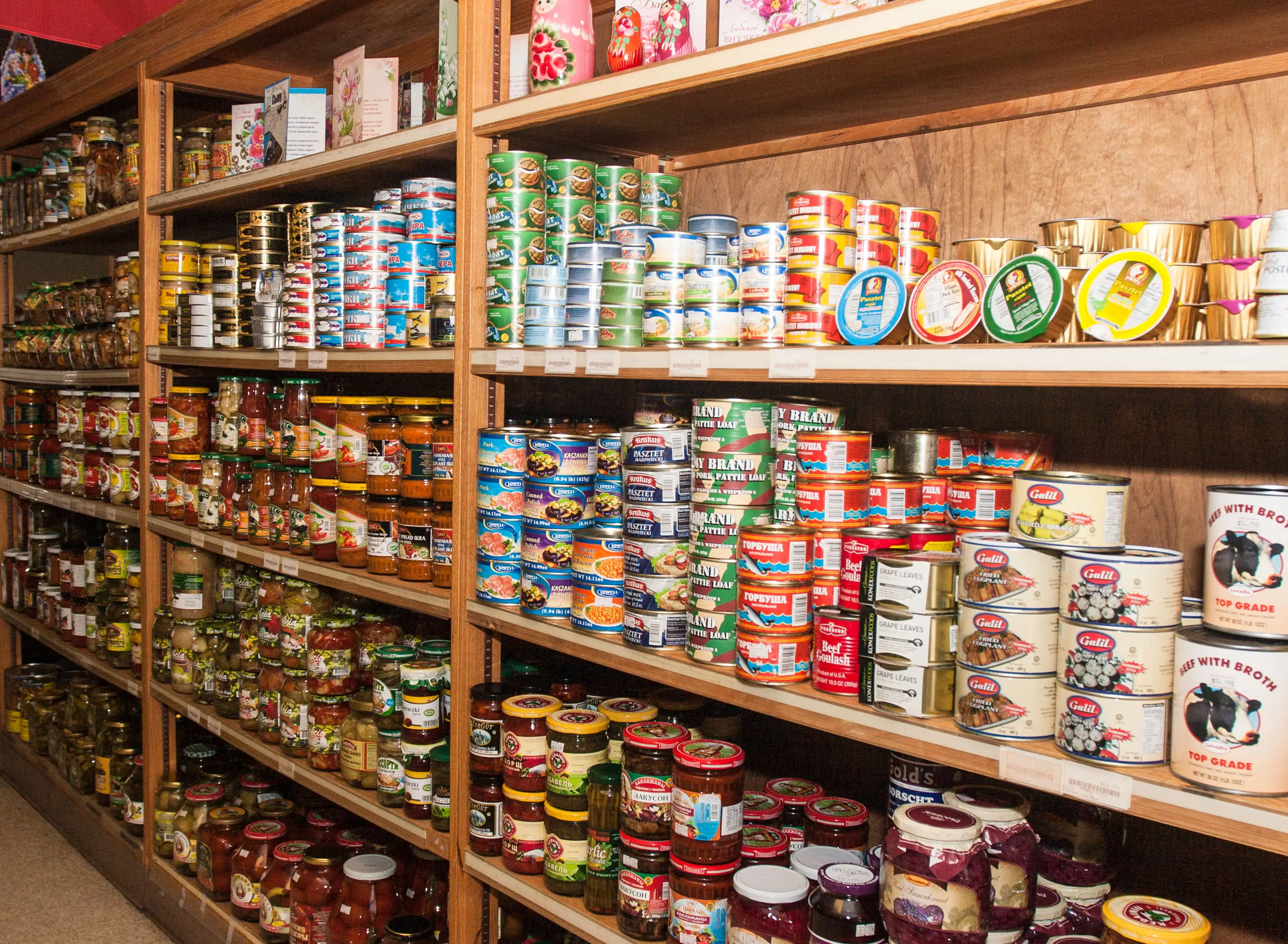 Interior shelves at Aleksey's Market stocked with imported jars, canned foods, and pantry staples.